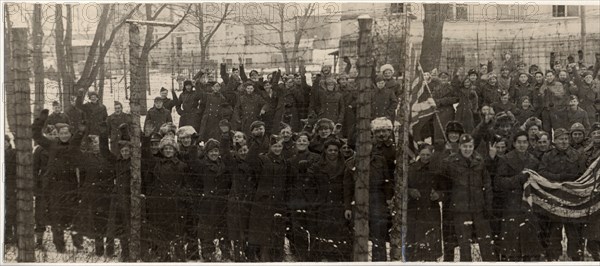 The red army freed them, americans and british prisoners of war in the yard of a german prison camp, near poznan,  they wanted to have their pictures taken behind the barbed wire fence, which separated them from the rest of the world for several years.