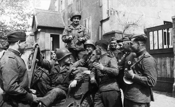 Soviet and american soldiers chatting after meeting at the elba river on april 25, 1945.