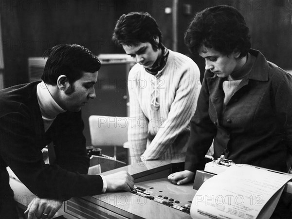 Students j, jankowska and cz, debicka discussing the workings of a digital computer with their instructor, j, wolanski at the laboratory of the center of perfection of the technical personnel in wroclaw, poland, 1972.