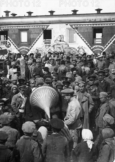 People listening to a speach of a people's commissar being played on a gramaphone, 1920, propaganda train bringing movies and recordings to to reach and instruct the peasantry.