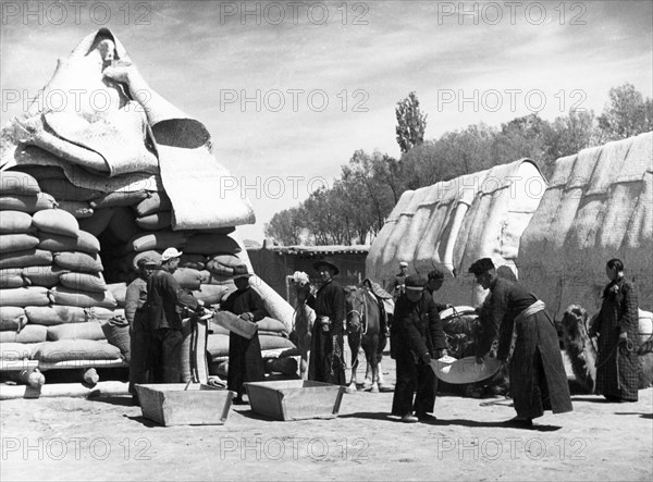 Mongolian herdsmen buying food at a state grain supply center in payinhota, the seat of the mongolian autonomous government in ningsia province, china, august 1954.