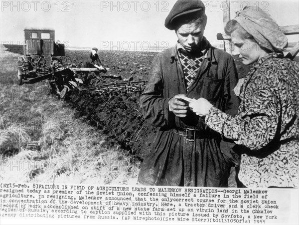 A tractor driver and clerk checking the record of work accomplished on a shift of a new state farm set up on virgin land in the chkalov region of russia, 1955.