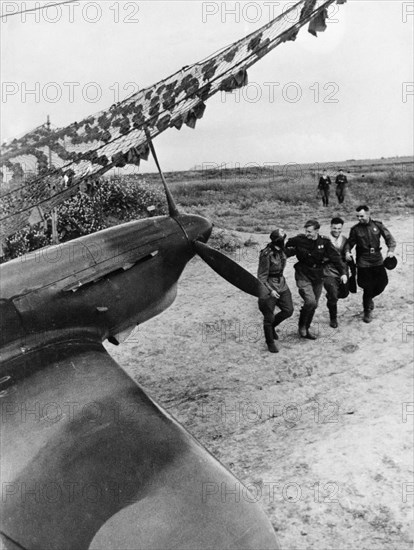 Soviet pilots greeting each other after a mission, yakovlev yak fighter of the soviet air force is in the foreground.