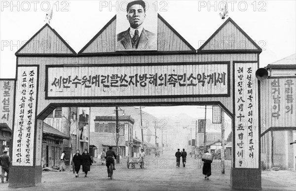 Portrait of kim il sung over a street in the town of kaishu, north korea, may 1947.