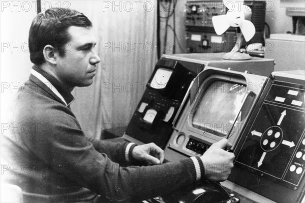 Luna 21 mission, a technician working the controls of the soviet remote-controlled lunar rover, lunokhod 2 at the distant space communications center, january 1973, (wire photo).