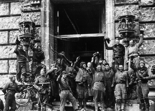 Soviet red army soldiers celebrating outside the reichstag (chancery) building, fall of berlin, may 1945, world war 2.