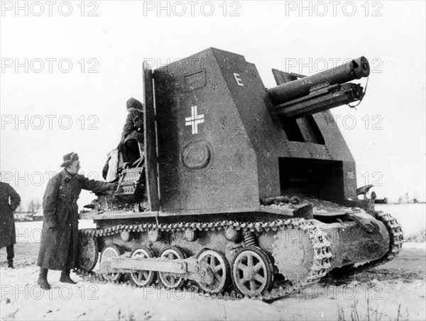 Somewhere in russian in march 1942, soviet soldiers look over a piece of captured nazi artillery mounted on an armored tractor.