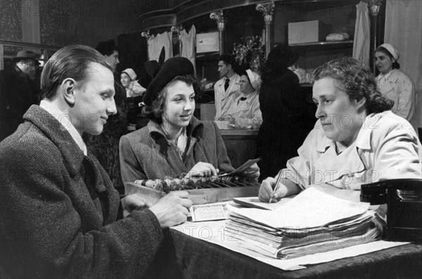 Moscow on the eve of may day, a couple placing an order for the holidays at the home delivery department of 'gastronom' food shop no, 2, april 1952.