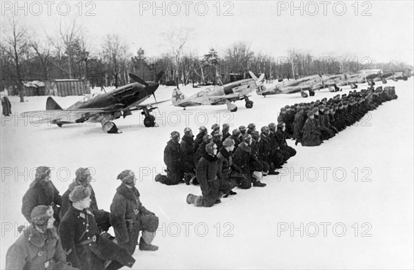 World war 2, members of a guards unit taking the guardsmen's oath on a snow covered airfield on the soviet/german front, soviet air force mikoyan-gurevich mig-3 (i-18) fighters in winter camouflage are lined up behind them, defense of moscow, 1942.