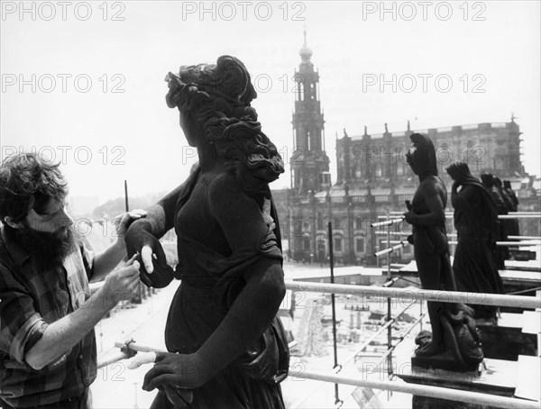 Sculptor peter flade, one of many craftsmen working on the restoration of the semper opera house in dresden, germany which was destroyed by bombing, 1978, this is part of an on-going effort to rebuild the city after it's destruction during world war 2.