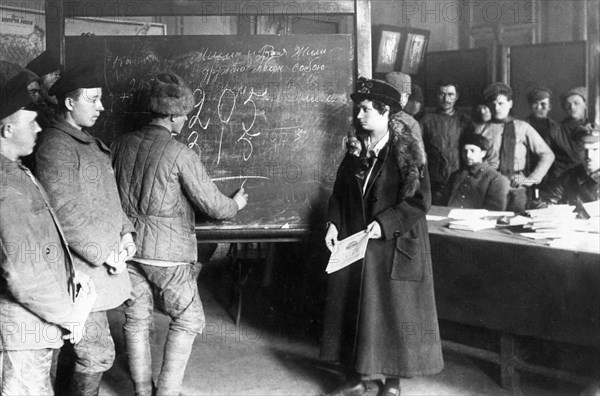 An early post-revolution classroom where adults are being taught to read, write, and do arithmatic, 1920s.