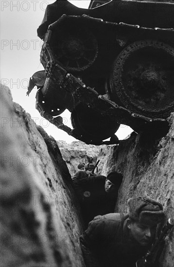 World war 2, battle of kursk, soviet t-34 tank driving over a trench with red army soldiers, 1943.