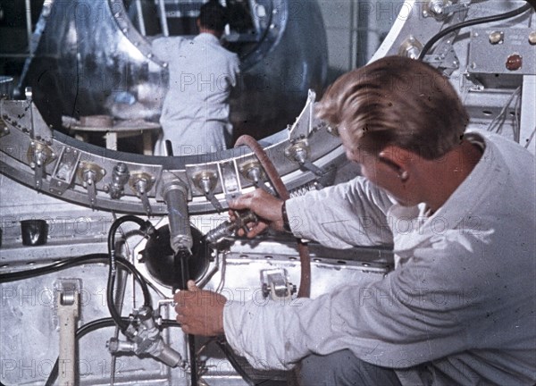 Work being done on the vostok 1 capsule in preparation for gagarin's historic flight, 1961, this is a still from a soviet film about the space program.