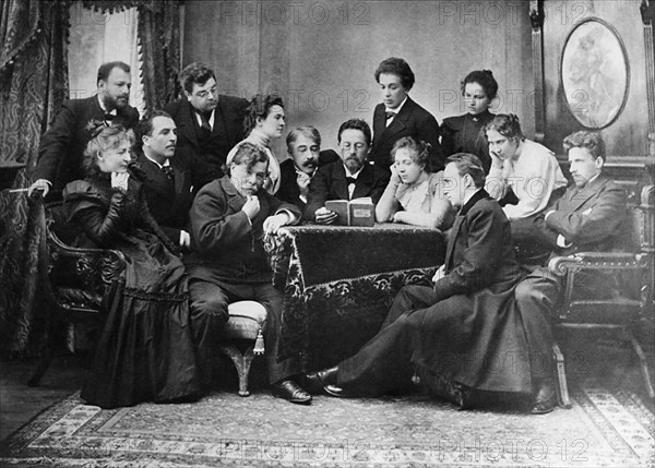 Anton chekhov reads his play 'the seagull' to actors of the moscow art theatre, 1899, chekhov center with book in hand, director and actor konstantin stanislavsky to his left, standing beside stanislavsky: olga knipper (chekhov's future wife), front, stroking beard: actor a, artem, far left, standing (with beard) v, nemirovich-danchenko, setaed, far right: v, meyerhold.