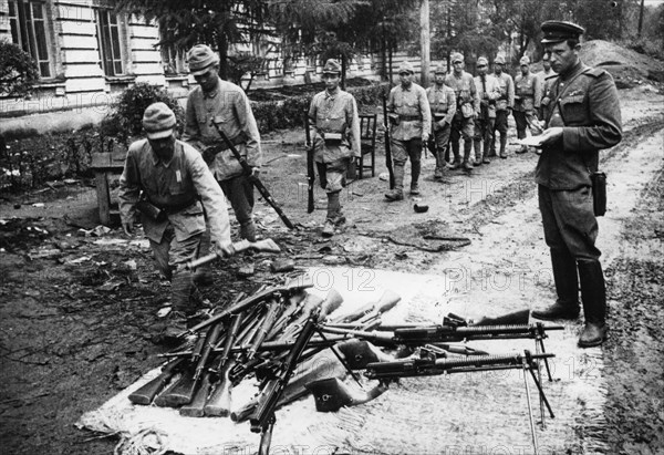 Operation august storm (battle of manchuria), japanese soldiers who defended harbin from red army surrender their weapons, harbin, manchuria, soviet officer (right) takes inventory, august 20th, 1945, world war 2.