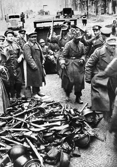 German soldiers surrendering their weapons to soviet red army troops in berlin, germany, 1945.