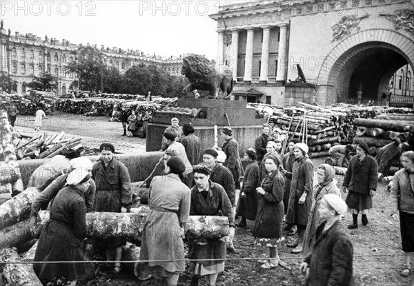 Leningraders fill with earth and rubble a crater dug out by explosion of a nazi bomb on the neva's embankment near the rostral column.