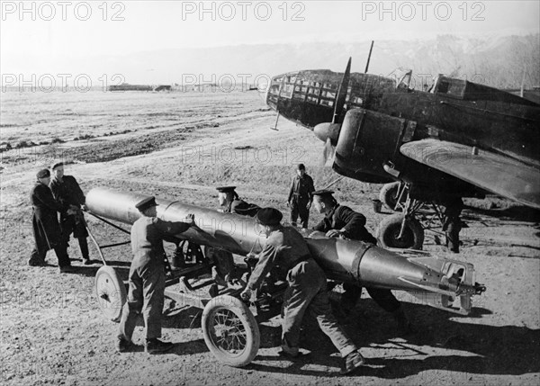 Black sea fleet, soviet ground crew loading a torpedo onto an il-4 medium bomber.