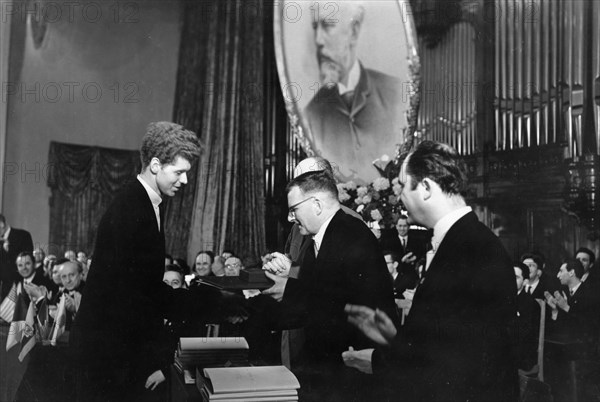 During the closing ceremonies of the tchaikovsky international violin and piano competition, soviet composer d, shostakovich presents a gold medal and a diploma of honor to american pianist van cliburn, the winner of the competition, april 14, 1958.