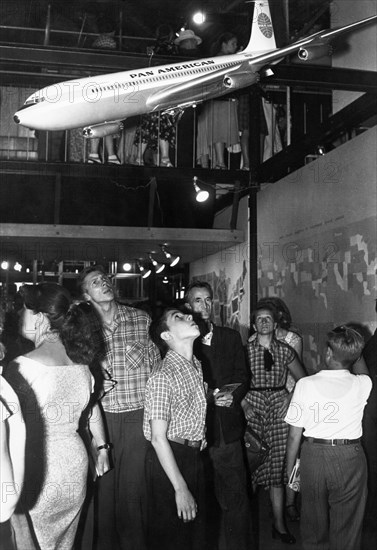 People examining a model of a boeing 707 on display at the main pavilion of the american national exhibition in moscow, ussr, august 1959, 'it seems that our plane is better ,,,' (from the original caption comparing it to the tu-104).