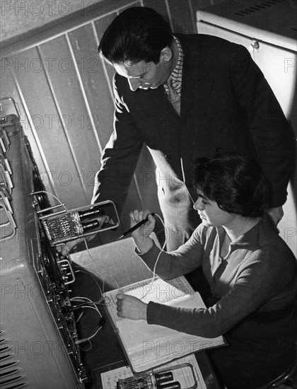 Chief engineer j, skrins and technician m, kovalyeva checking over blocks of a besm-2 computer installed at the new computing center at latvia's p, stuchki state university in riga, 1961, this center will serve the industrial enterprises and scientific establishments of latvia and the other baltic republics.