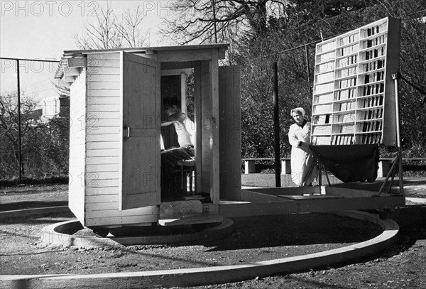 V, basokovskaya, a nurse of the ordjonikidze sanatorium of the sochi-matsestinsk resort, treating a patient with sun rays via a large concentrating solar reflector, the past year showed good results in the treatment of joint disease, bronchial asthma, scaly herpes,radiculitis and other ailments with sun rays, 1961.