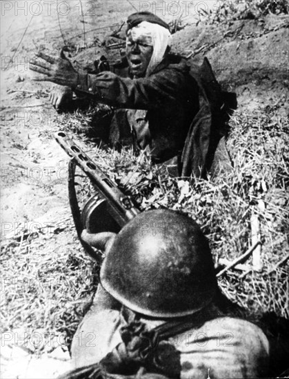 A wounded soldier fights against the nazis in the trench during world war ll.