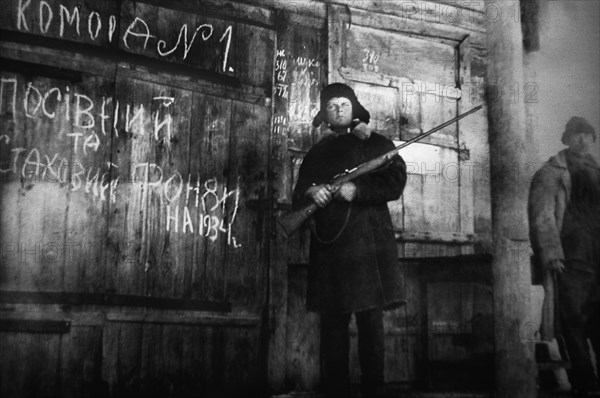 An armed man guards the storage of crop and emergency supply grain for the year 1934 in this documentary photograph displayed at an exhibition in kiev, dedicated to holodomor, the great ukrainian famine of early 1930s.