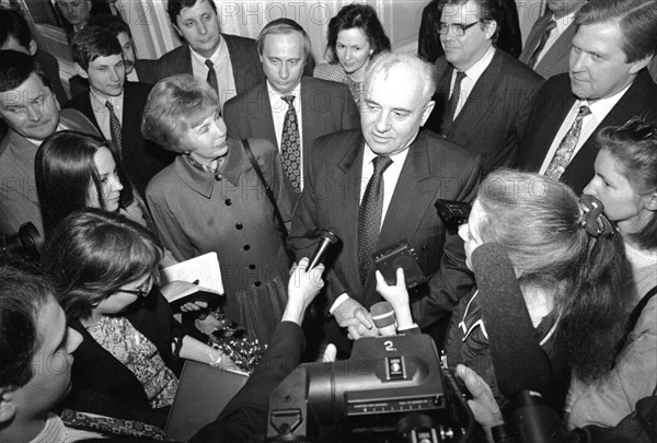 Ex-president of the ussr mikhail gorbachev and his wife raisa talking to journalists during gorbachev's visit to st,petersburg in april 1994, future president of russia, vladimir putin, is standing directly behind the gorbachevs.