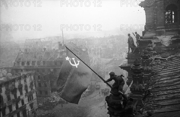 Red army soldiers raising the soviet flag over the reichstag in berlin, germany, april 30, 1945.
