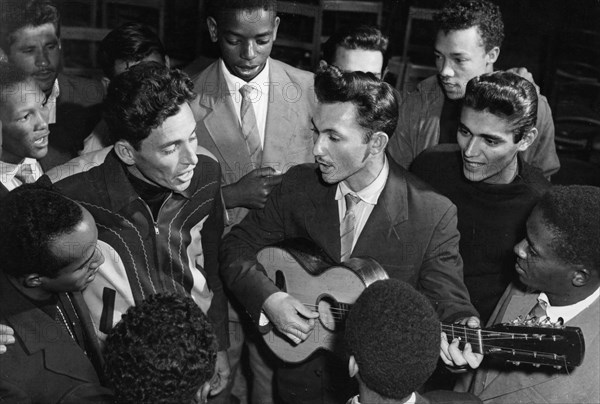 Cuban students, future machine operators, playing guitar and singing songs during their free time, cuba, 1961.