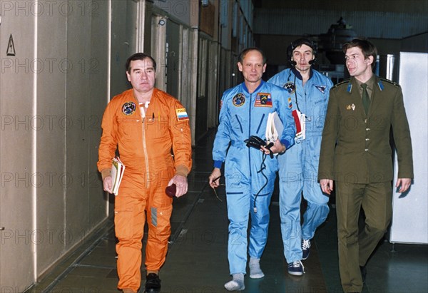 American astronauts bonnie dunbar, norman thagard, v, dezhurov, and us ambassador thomas pickering (bent) during survival training prior to the soyuz tm-21 mission to the mir space station, 1995.