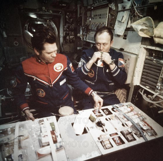 Soyuz 28 crew alexei gubarev and vladimir remek eating dinner aboard the salyut 6 space station, march 1978.