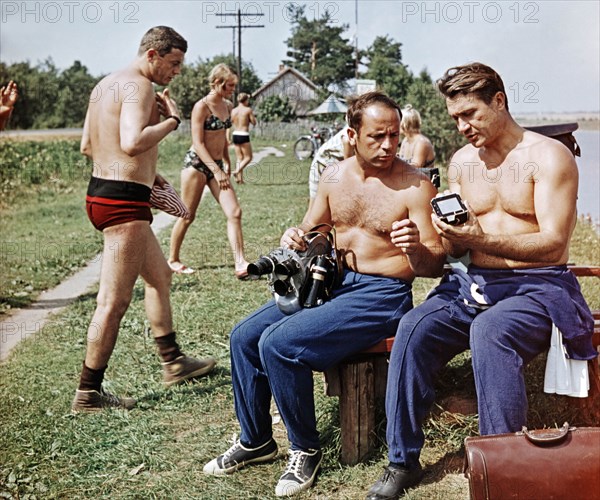 Soviet cosmonauts (l to r) vladislav volkov, viktor gorbatko, and anatoly filipchenko looking over a camera during a break from training for the soyuz 7 mission, ussr 1969.