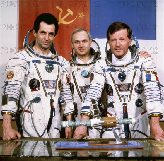 Salyut 7, soyuz t-6, cosmonauts aleksandr ivanchenkov, vladimir dzhanibekov, and jean-loup chrétien (france) pose with a model of the salyut 7 and soyuz spacecraft, 1982.