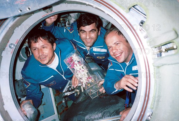 Russian cosmonauts viktor savinykh (left) and anatoly solovyov(right) and bulgarian astronaut alexander alexandrov (centre) seen pictured with orchids in the access hatch of the 'mir' space station, the 'mir'will plunge into the south pacific on march 23, the date was set on tuesday by a commission chaired by russian aviation and space agency director-general yury koptev, 1998.
