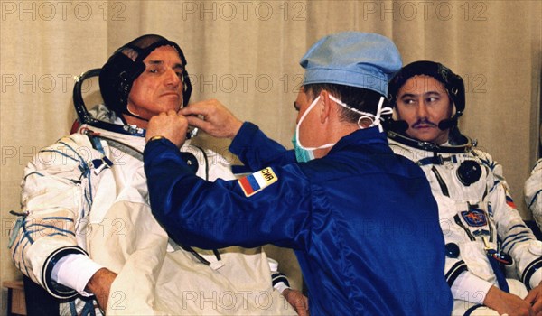 Baikonur, kazakhstan, april 18, 2001, first space tourist, dennis tito (l) and russian cosmonaut talgat musabayev (r) trying on their spacesuits in preparation for the flight to the iss, scheduled for april 28.