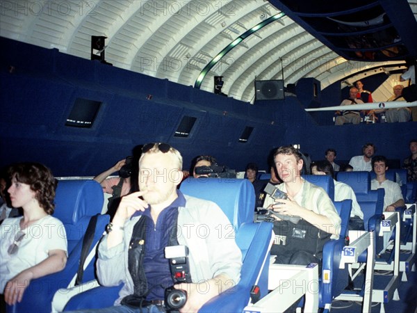 Moscow, russia 8/2000: a group of newsmen enjoy a simulated space flight aboard the buran space shuttle which was re-equipped as an amusement to launch a new entertainment at the gorky recreation park called 'space to earth'.
