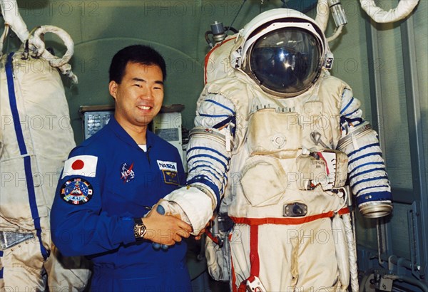 Japanese astronaut soiti noguti posing with a russian sokol spacesuit, 1998.