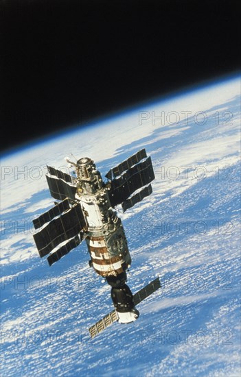 Soviet space station salyut 7 docked with a soyuz spacecraft (t-13?) orbiting planet earth, 1986.