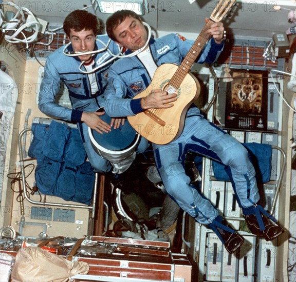 Soyuz tm-7: sergei krikalev (left) and alexander volkov play music aboard mir, 1989.