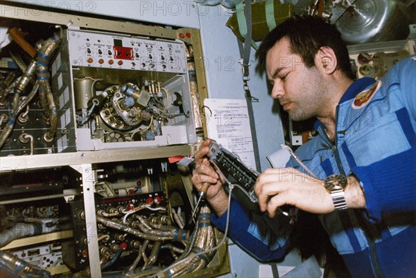 Mir, soyuz tm-2, cosmonaut aleksandr laveykin readies the svetlana elektrophoretic installation in the quantum module of the mir space station, 1987.