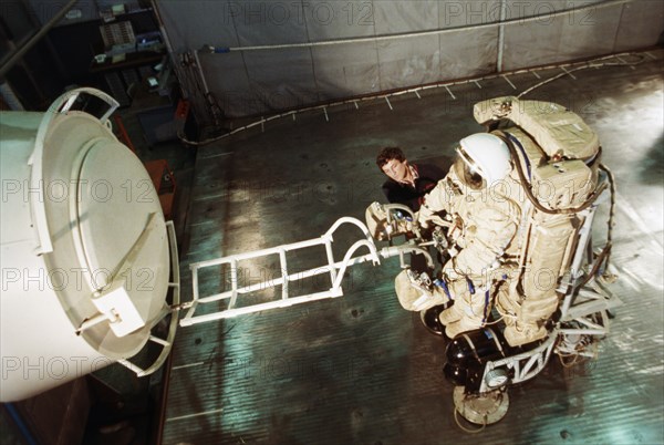 Engineer sergey zhizhkin experimenting with a new spacesuit at a recently de-classified aerospace facility, 1992.