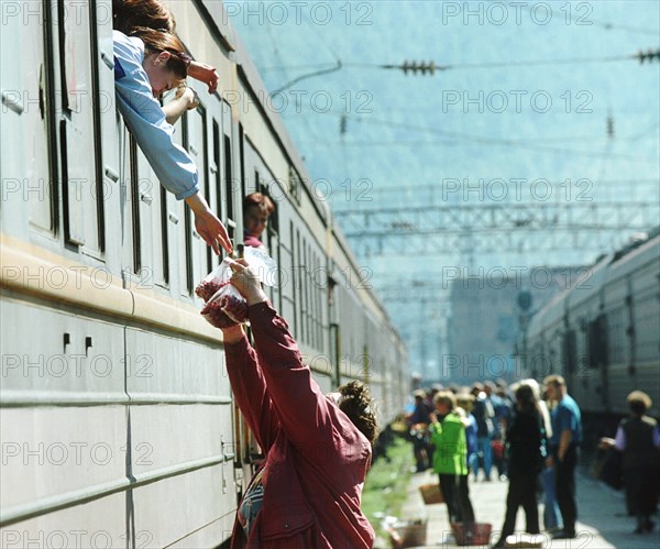 Irkutsk region, russia, october 8, 2003, a woman, resident of the town of slyudyanka, selling berries to passengers on the railway station, such trade is the main way of earning money for people in slyudyanka on the lake baikal.