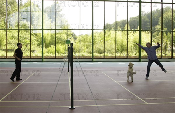 Sochi, russia, august 14, 2009, prime minister of russia vladimir putin and russian president dmitry medvedev (r) play badminton, as medvedev's golden retriever aldo runs around, after a working meeting prior to a meeting of the presidium of the council for priority national projects at the bocharov ruchei presidential residence.