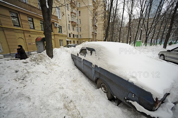 Moscow, russia, february 4, 2010, abandoned car buried in snow outside a building in central moscow, russia is launching a cash-for-bangers scheme in march 2010 to encourage motorists to scrap their used cars in favour of buying a new russian-made vehicle, the scheme gives drivers a 50000 rouble voucher to trade in cars that are more than 10 years old to buy a new model.
