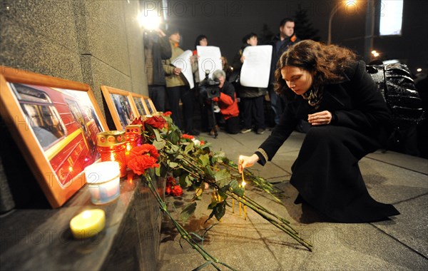 Moscow, russia, march 30, 2010, a woman lights candles to commemorate victims of the metro bomb explosions, blasts rocked two stations on sokolnicheskaya line of the moscow underground during the rush hour killing 38 and injuring over 60 passengers.
