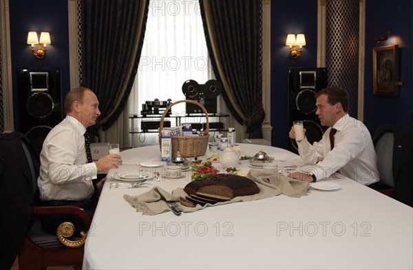 Moscow region, russia, october 1, 2010, president of russia dmitry medvedev (r) and prime minister vladimir putin have a snack together during their meeting at gorki residence  with milk products from ruzskoye moloko dairy company.