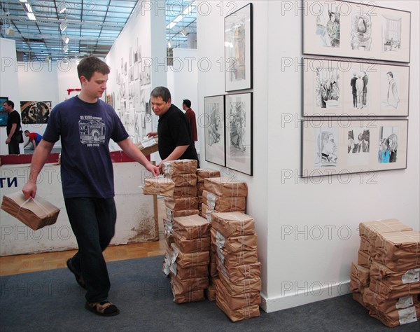 Moscow, russia, may 24, 2005, a stand (r) with drawings made by pavel shevelev (l) during a trial of mikhail khodorkovsky and platon lebedev, drawings on khodorkovsky-lebedev trial are exhibited in the kovcheg gallery within the framework of the 'art moscow' exhibition opened in the central house of painter.