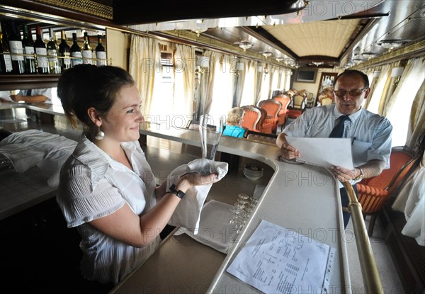 Moscow, russia, august 16, 2011, bar tender with a glass in hands, in a diner car on a moscow-to-beijing passenger train